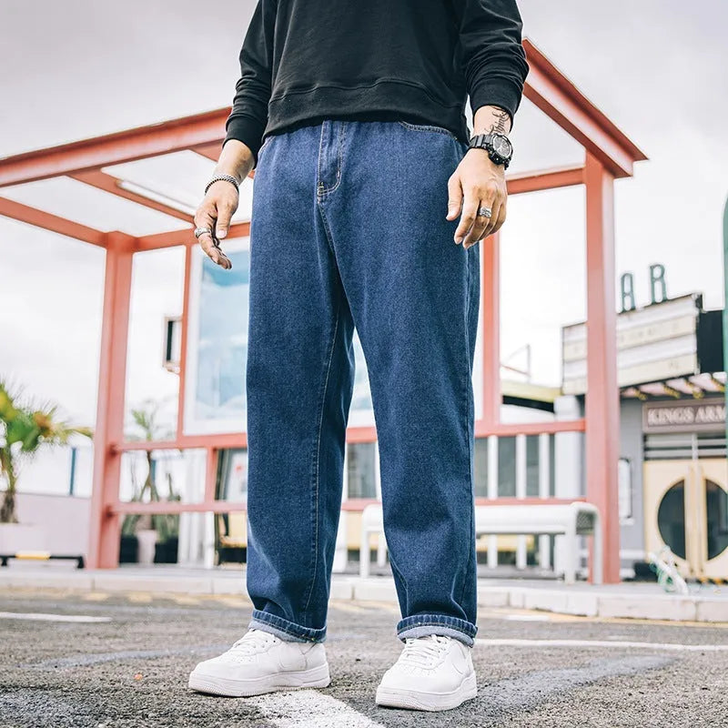 Men's dark blue loose straight fit cotton jeans with a zipper fly, shown on a hanger.