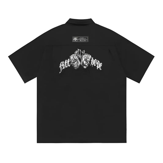 Man wearing a black cotton blend half-sleeve loose fit work shirt with embroidered detail.
