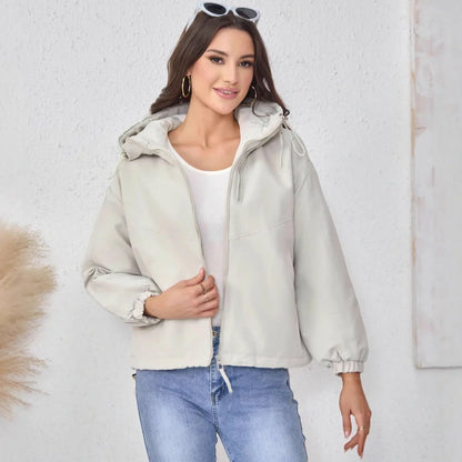 Women's grey hooded shell jacket with loose fit and long sleeves on hanger