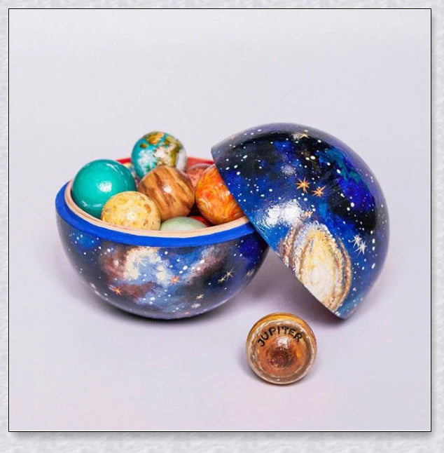 Detailed wooden solar system model with hand-painted planets, astronaut figure, and rocket for interactive space learning and exploration.