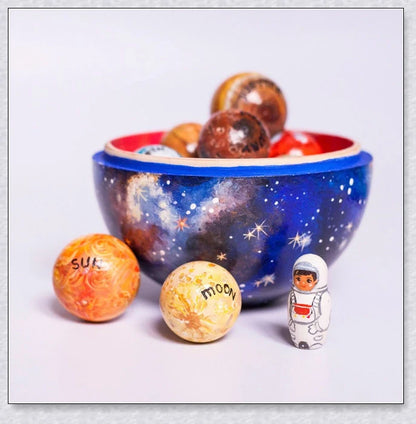 Detailed wooden solar system model with hand-painted planets, astronaut figure, and rocket for interactive space learning and exploration.