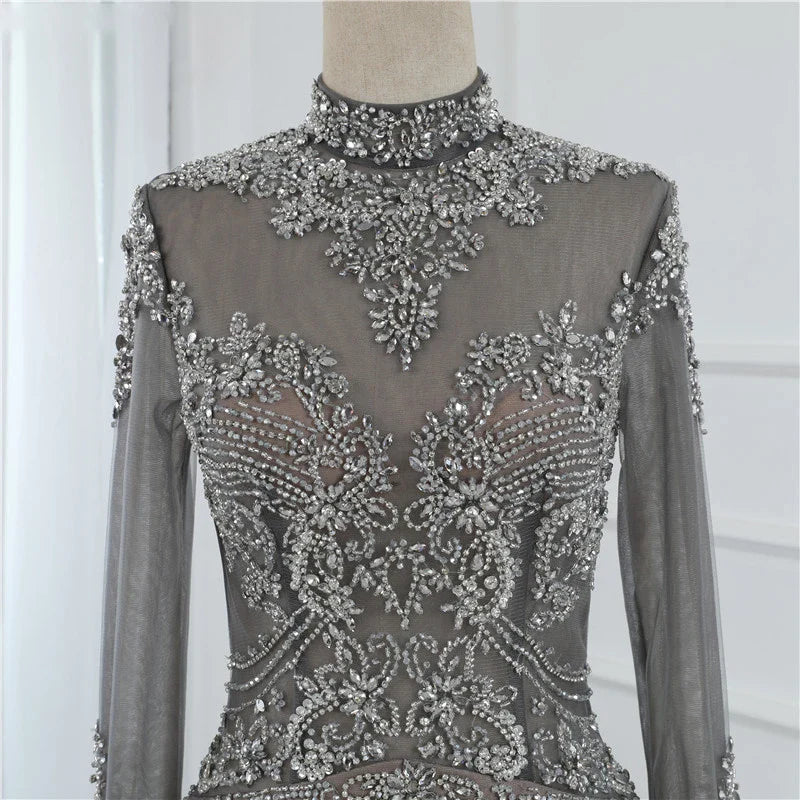 A long sleeve fishtail slim dress with a high waist, zipper closure, and Austrian diamond accents for a sophisticated and elegant look.