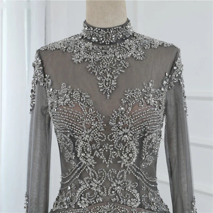 A long sleeve fishtail slim dress with a high waist, zipper closure, and Austrian diamond accents for a sophisticated and elegant look.