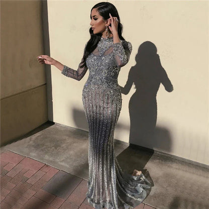 A long sleeve fishtail slim dress with a high waist, zipper closure, and Austrian diamond accents for a sophisticated and elegant look.
