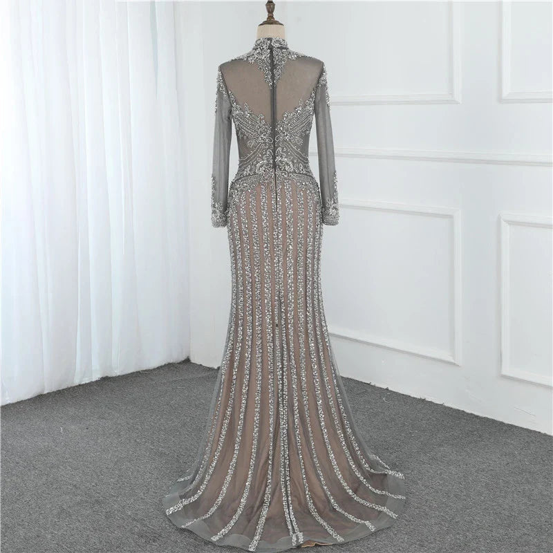 A long sleeve fishtail slim dress with a high waist, zipper closure, and Austrian diamond accents for a sophisticated and elegant look.