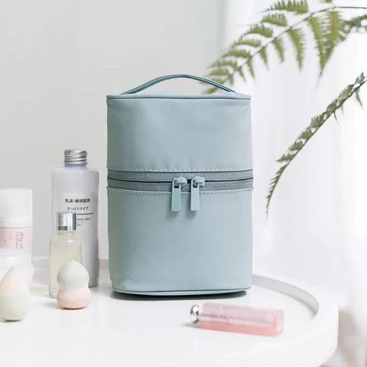 A cylindrical nylon makeup storage bag in a green color, designed for portable and organized beauty on the go.