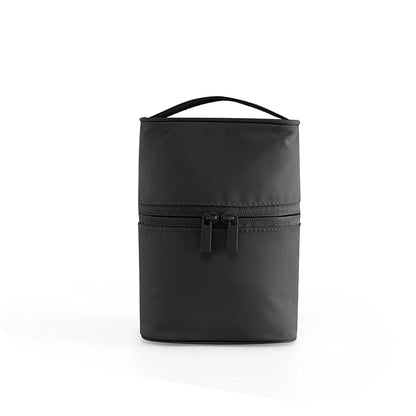 A cylindrical nylon makeup storage bag in a green color, designed for portable and organized beauty on the go.