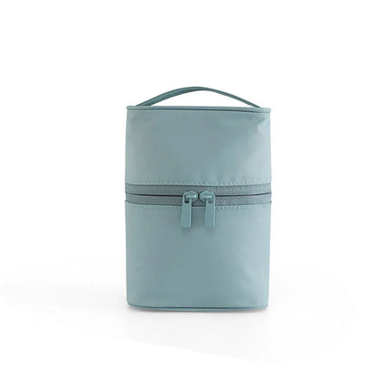 A cylindrical nylon makeup storage bag in a green color, designed for portable and organized beauty on the go.