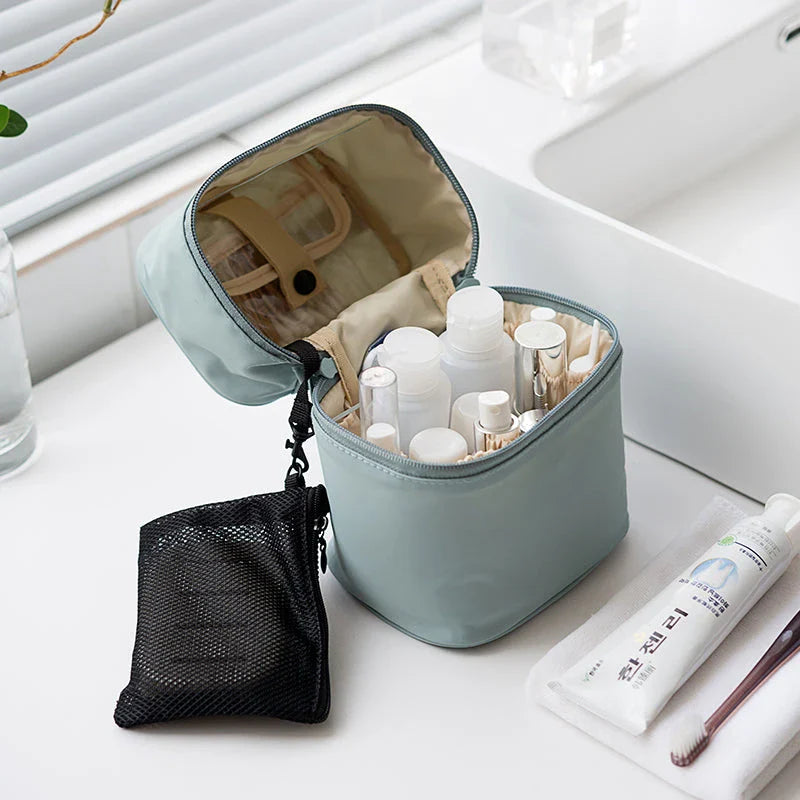 A cylindrical nylon makeup storage bag in a green color, designed for portable and organized beauty on the go.