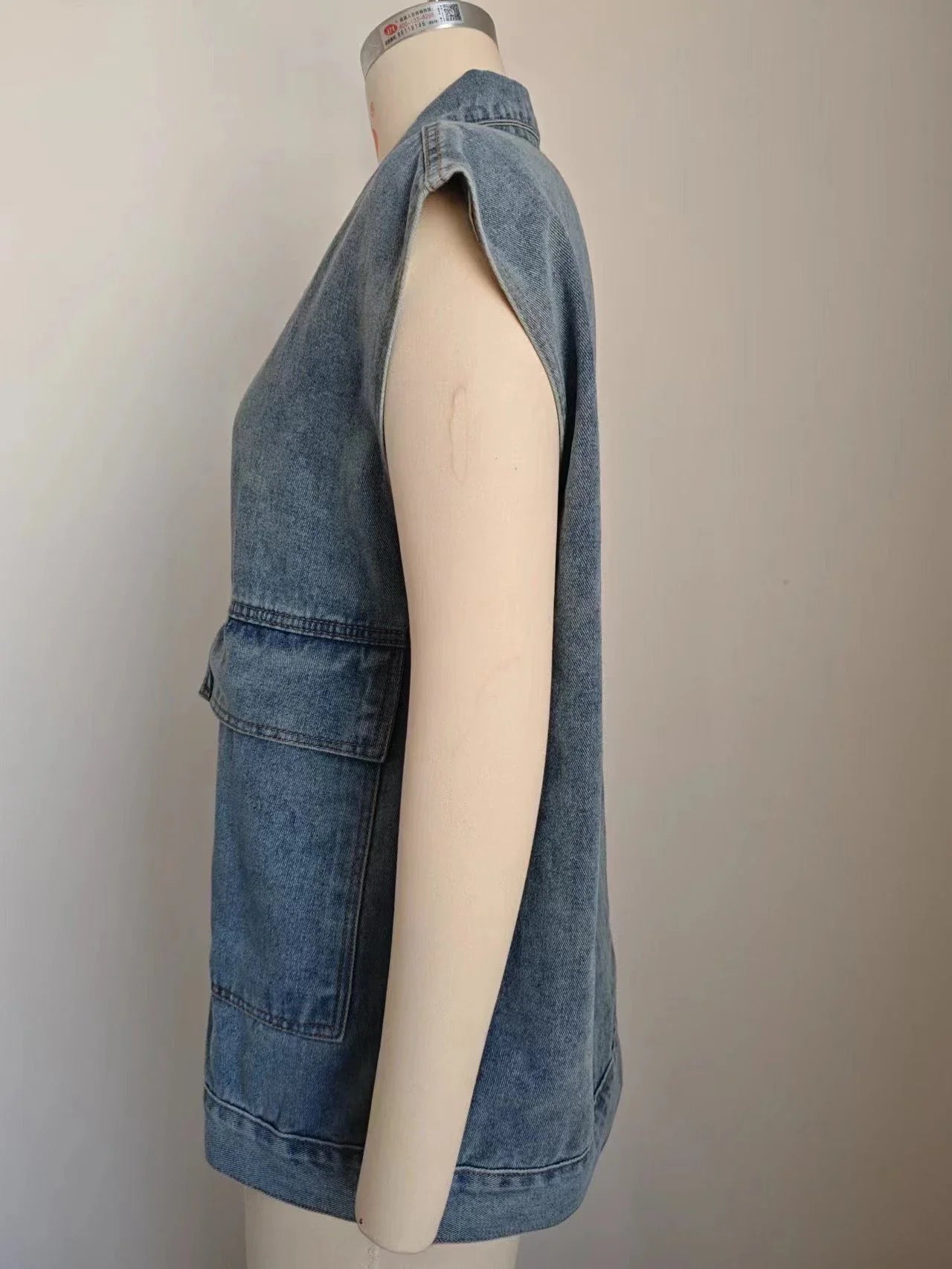 Denim vest with large pockets, sleeveless design, and fashionable silhouette for women's casual and everyday wear