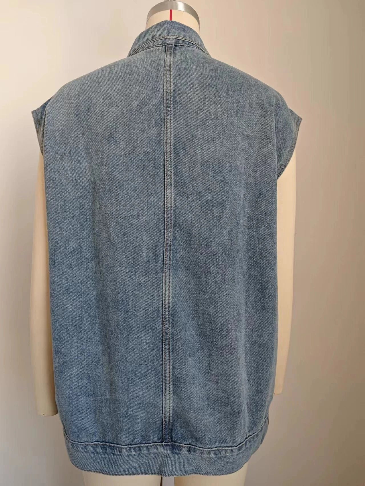 Denim vest with large pockets, sleeveless design, and fashionable silhouette for women's casual and everyday wear