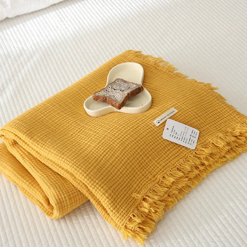 Four-layer gauze tassel blanket in cotton, showing tassel edges and textured fabric, available in multiple colours and sizes