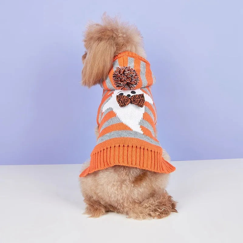 Orange Halloween pet sweater with knitted stripes, fur ball accents, and hood for cats or dogs