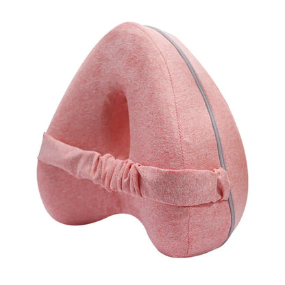 Dark blue jacquard heart-shaped memory foam leg pillow for adults on a bed.