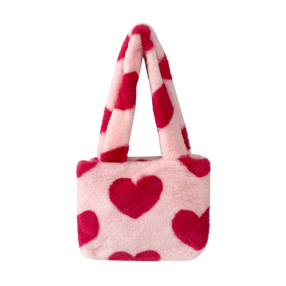 Soft, plush heart-shaped handbag in various vibrant colors with a magnetic closure and interior phone compartment