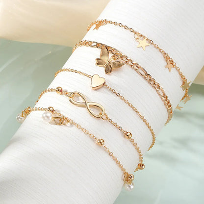 Four-piece women's anklet set with butterfly, pearl, and heart designs in alloy metal