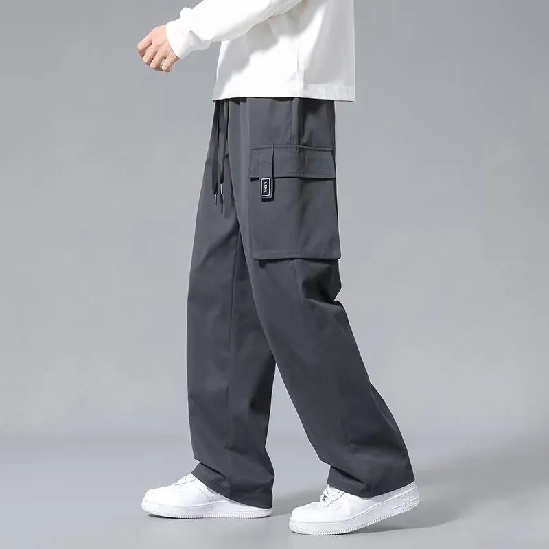 Boys in straight leg cargo trousers with drawstring waist and large side pockets, shown in Army Green.