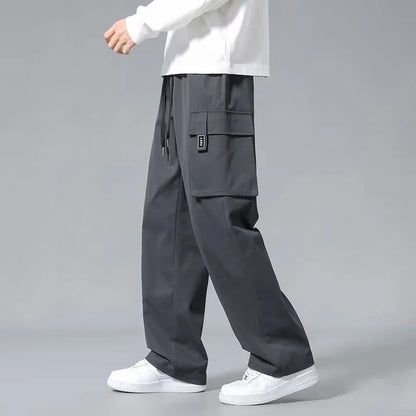 Boys in straight leg cargo trousers with drawstring waist and large side pockets, shown in Army Green.