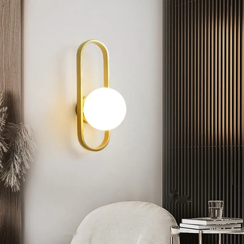 Minimalist wall lamp in black or gold finish with glass shade and 12W tri-colour LED lighting
