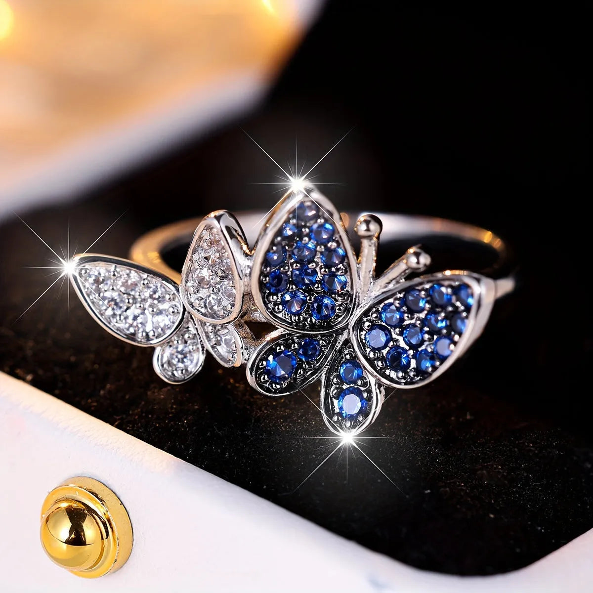 Silver-tone blue and white butterfly design ring for women on a white background.