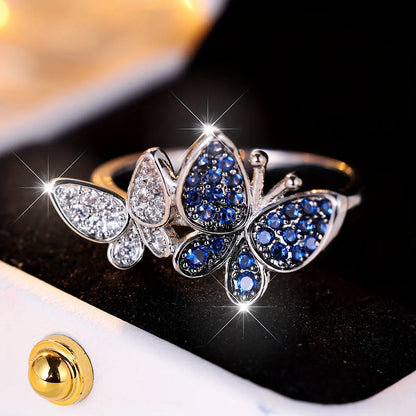 Silver-tone blue and white butterfly design ring for women on a white background.