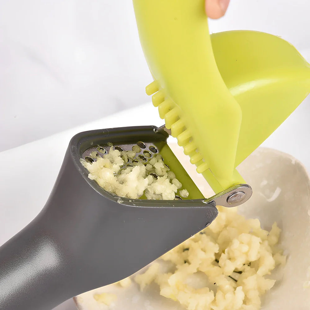 White plastic garlic masher with stainless steel crushing grid and ergonomic handle for kitchen use