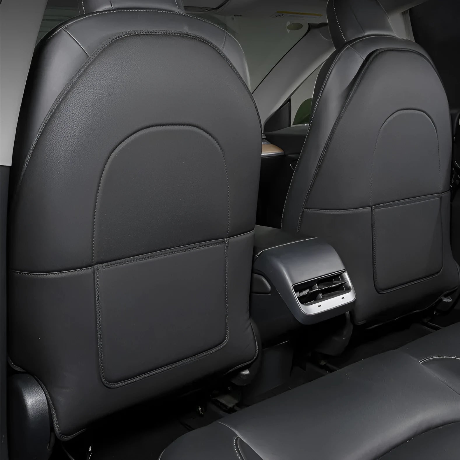 Set of two black leather rear anti kick pads for car seat back protection.