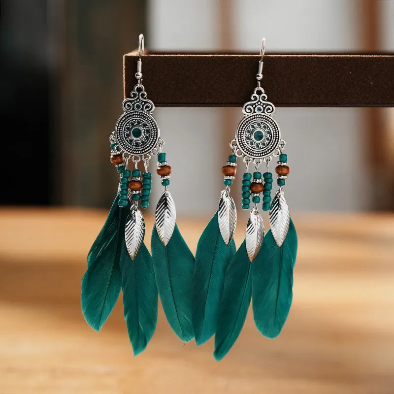 Bohemian feather leaf pattern alloy earrings in round drop shape on a colour selection background.