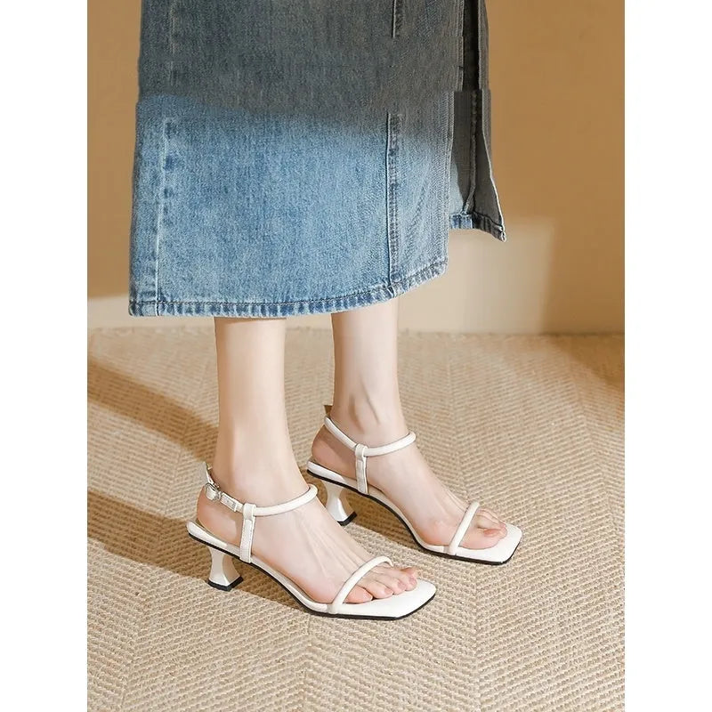 Black women's high heel sandals with a single ankle strap, square toe, and thick heel.
