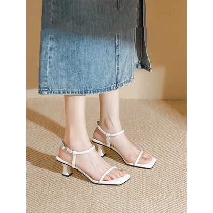 Black women's high heel sandals with a single ankle strap, square toe, and thick heel.