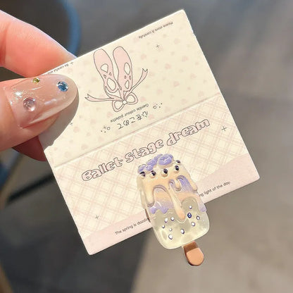 A resin hair barrette with a cartoon ice cream charm on a side-clip, shown in a pink colour variant.