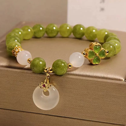 Green tourmaline women's bracelet with four-leaf clover safety buckle and geometric drop shape.
