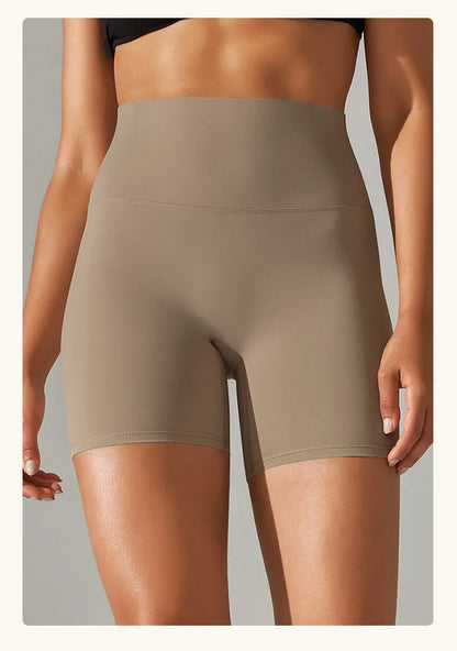 Woman wearing high waist hip lift fitness tights in a neutral colour, suitable for running or gym workout.