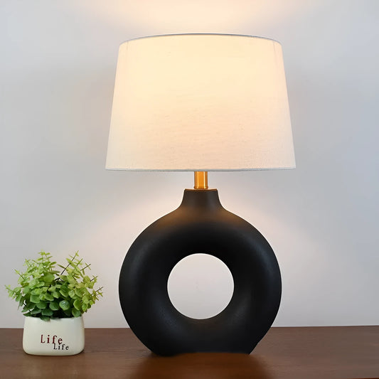 Feng Japanese style white pottery pot table lamp on a desk.