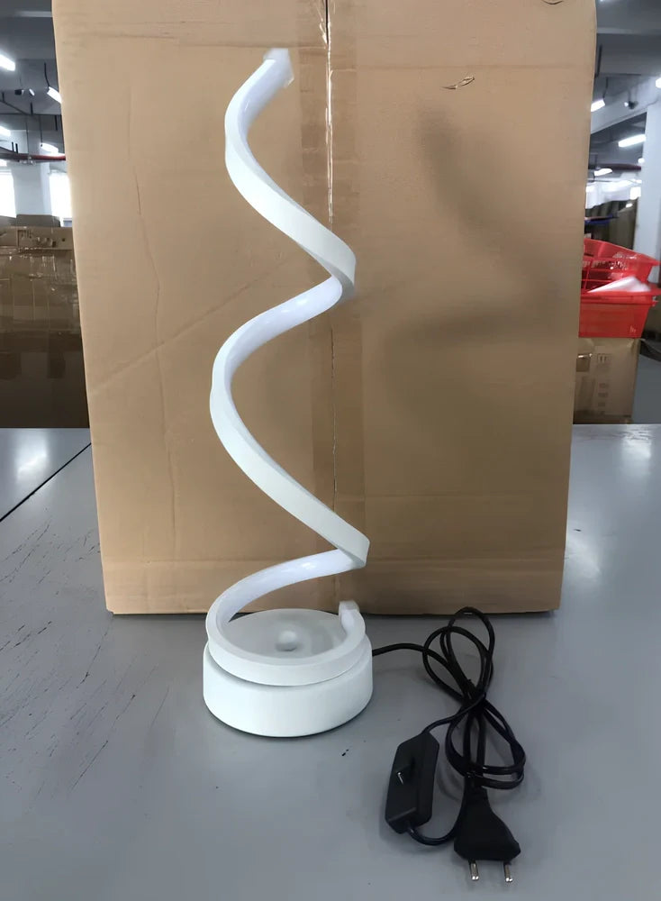 Modern table lamp with curved design, metal base, and acrylic shade offering remote-controlled dimming between warm and white light