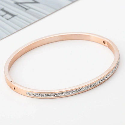 Elegant stainless steel bracelet with diamond accent, available in gold, rose gold, and steel finishes.