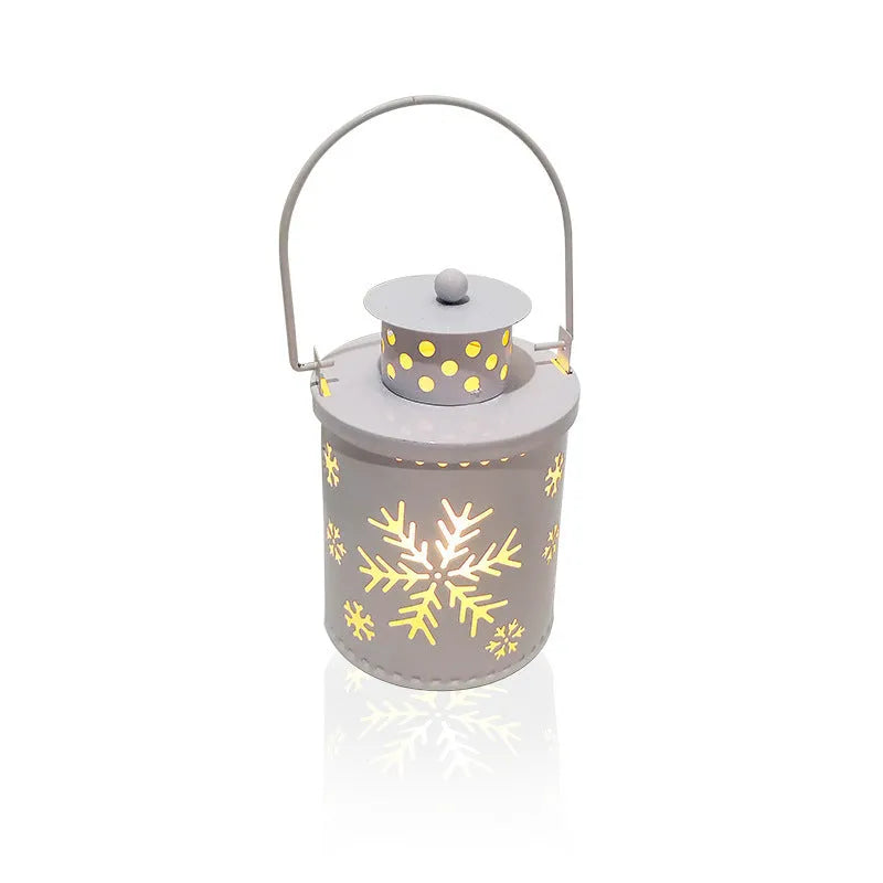 Green wrought iron electronic candle lantern with flickering LED light on a wooden mantel.