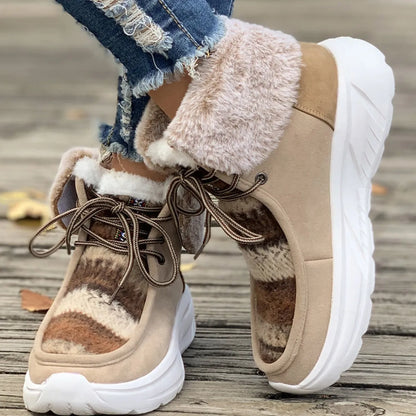 Women's lace-up snow boots in beige with suede upper, thermal fur lining, and non-slip rubber sole on a winter background