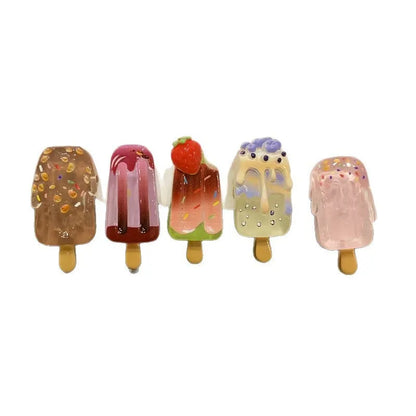 A resin hair barrette with a cartoon ice cream charm on a side-clip, shown in a pink colour variant.