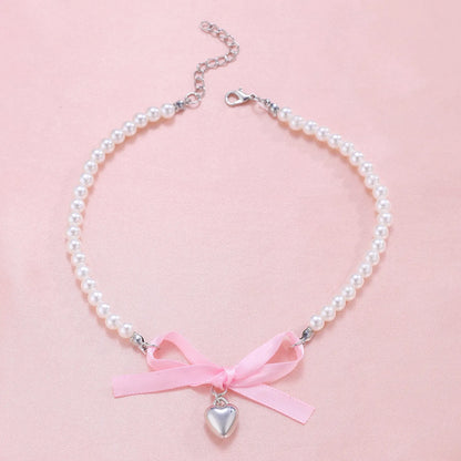 Love heart and bow tie clavicle chain necklace with pearl inlay, shown in White K Love 028 and White K Bow 026 options.