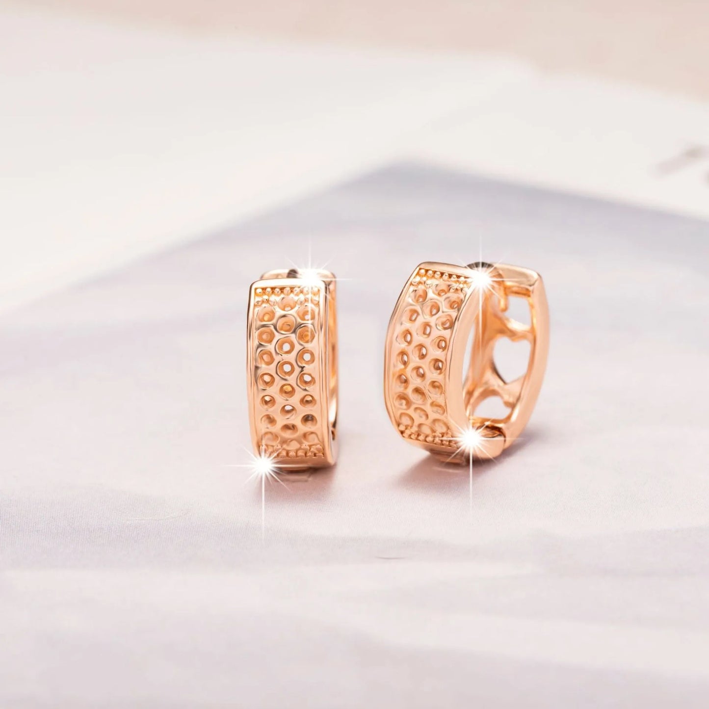 Rose gold electroplated earrings with 2.5cm circular design and three heart-shaped cut-outs
