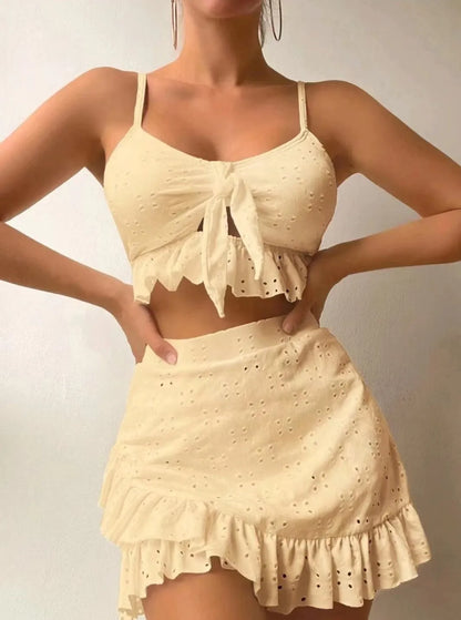 Women's white split hip skirt three-piece bikini swimsuit set on a mannequin.
