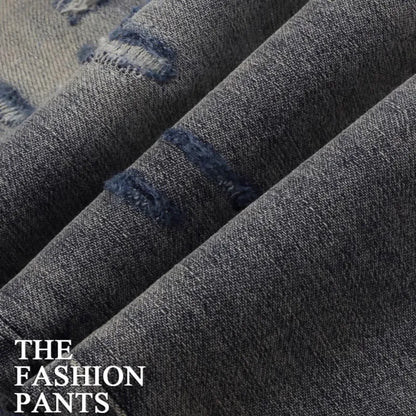 Men's slim fit blue jeans with washed-out finish, hole patches, and embroidery detail.