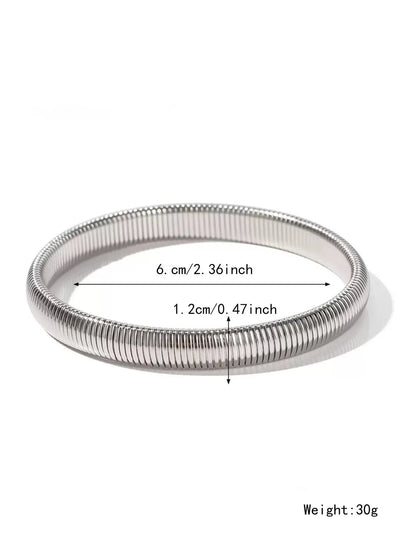 Women's titanium steel elastic bracelet with a vertical stripe pattern in gold, shown on a wrist.