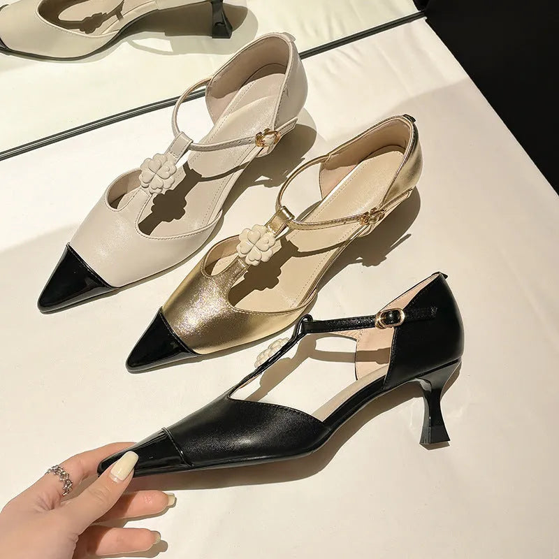 Women's black pointed toe stiletto heel shoes with floral buckle on sheepskin upper.