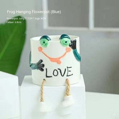 Ceramic hanging foot flowerpot for succulent plants with cartoon styling on desktop