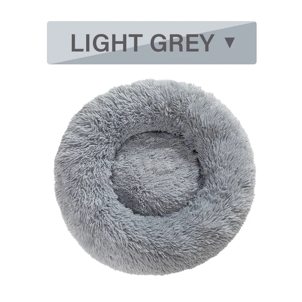 Fluffy donut-shaped dog bed in dark grey colour with raised edges, showing plush texture and circular design