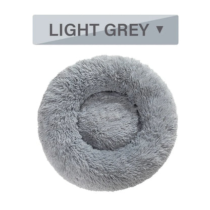 Fluffy donut-shaped dog bed in dark grey colour with raised edges, showing plush texture and circular design