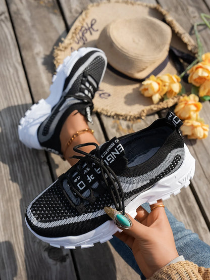 Women's Flyknit mesh lace-up sneakers in a grey colourway on a white background