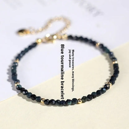 Close-up of a blue tourmaline beaded bracelet with 3mm stones and spacer beads on a wrist.